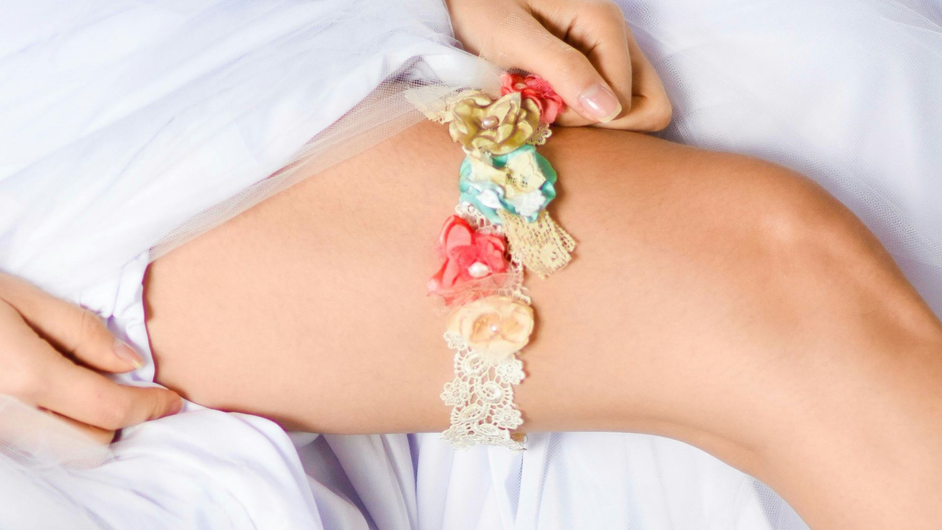 woman in white dress wearing red and white floral bracelet