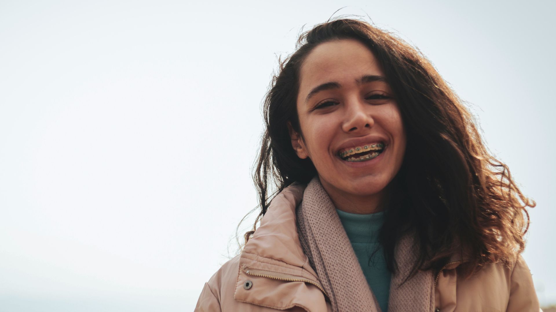 a woman holding a cup of coffee and smiling