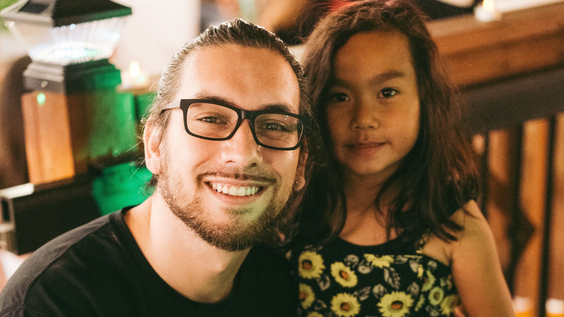 man in black crew neck t-shirt beside woman in green and white floral dress