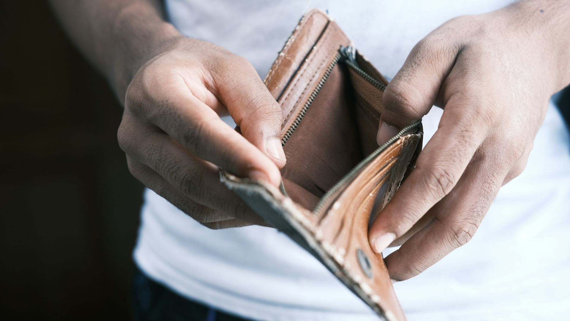 person holding brown leather bifold wallet