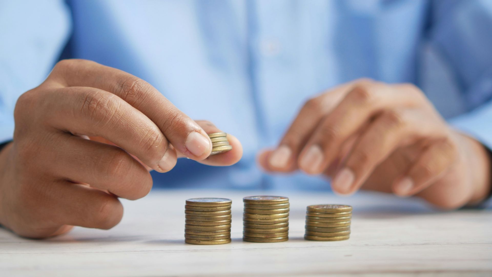 a person stacking coins on top of a table