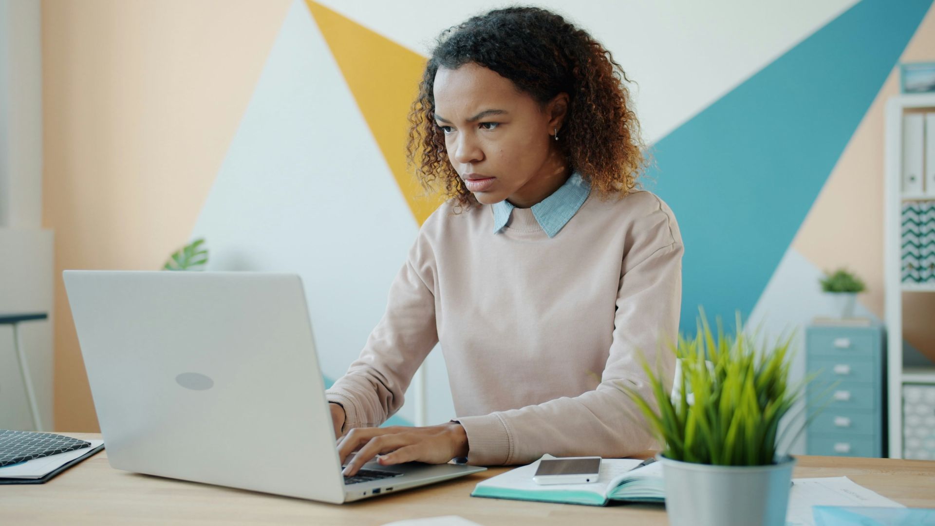 Young woman concentrating while working on a laptop.