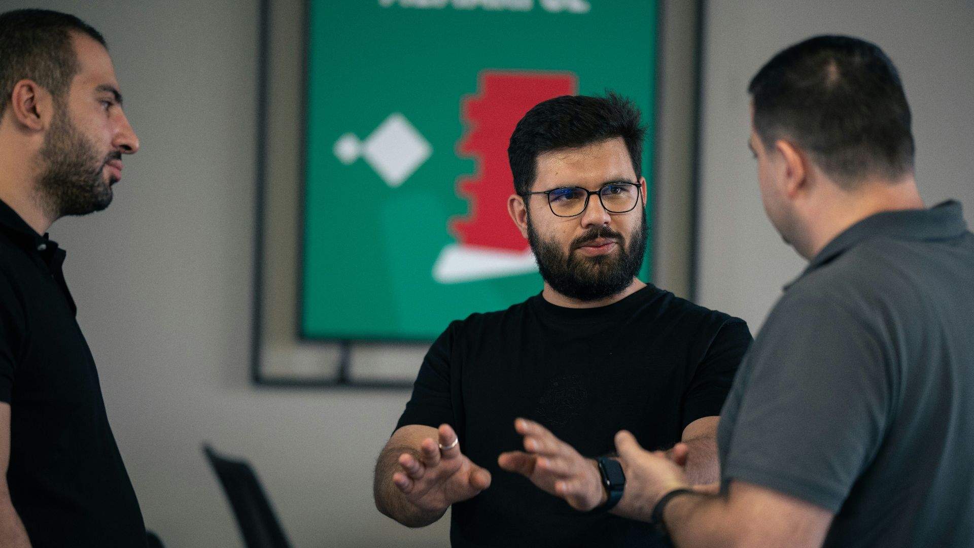 A group of men standing around each other in a room