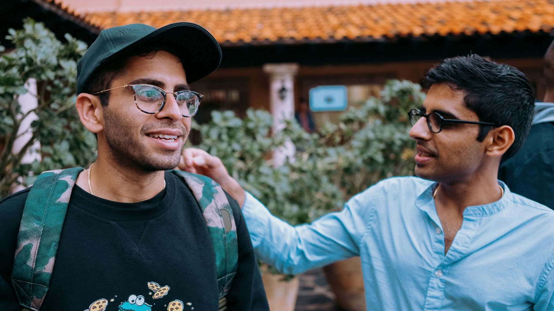 man in black crew neck shirt wearing black framed eyeglasses and black hat