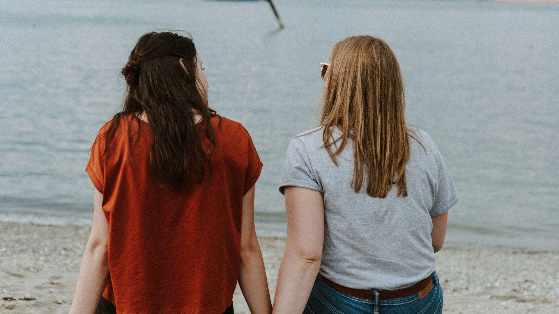 two women sitting on log
