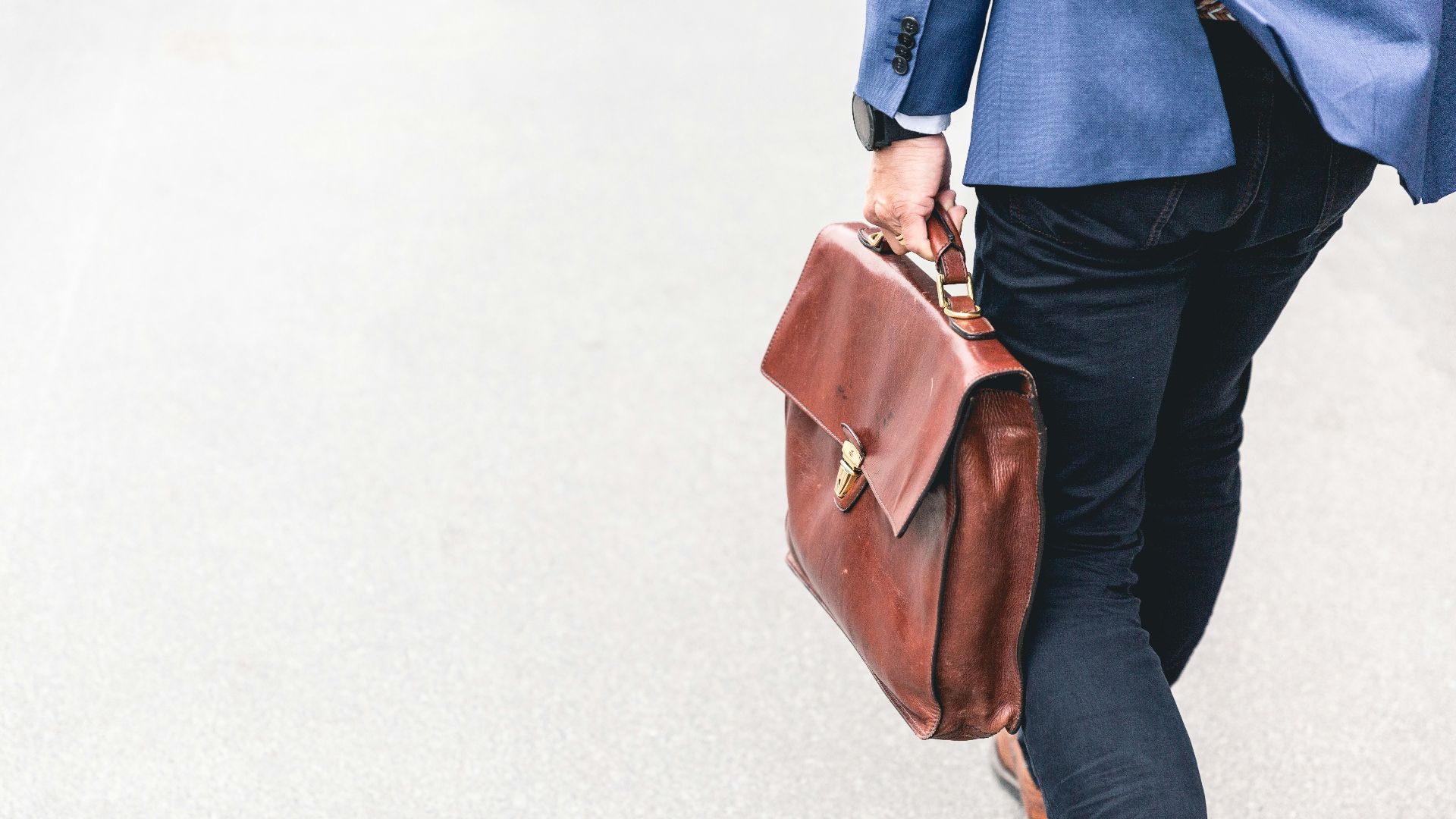 person walking holding brown leather bag