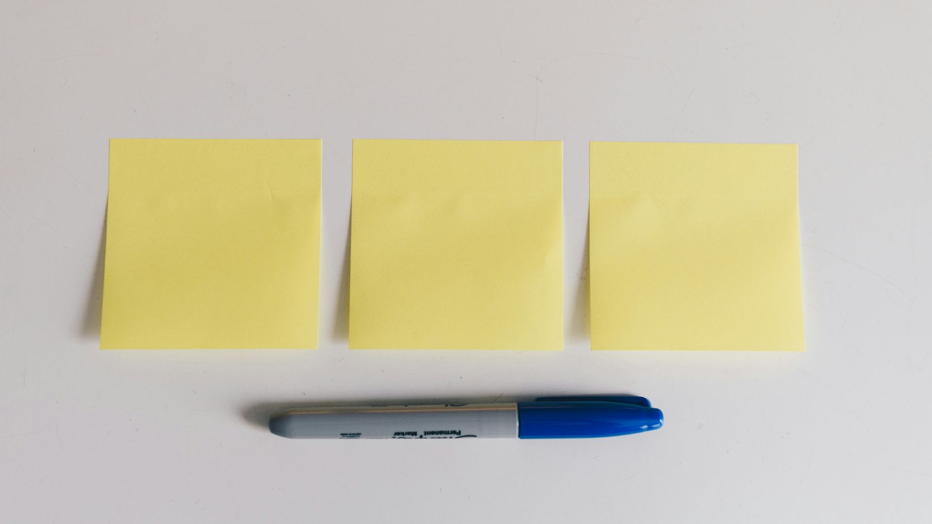 blue sharpie beside yellow sticky notes