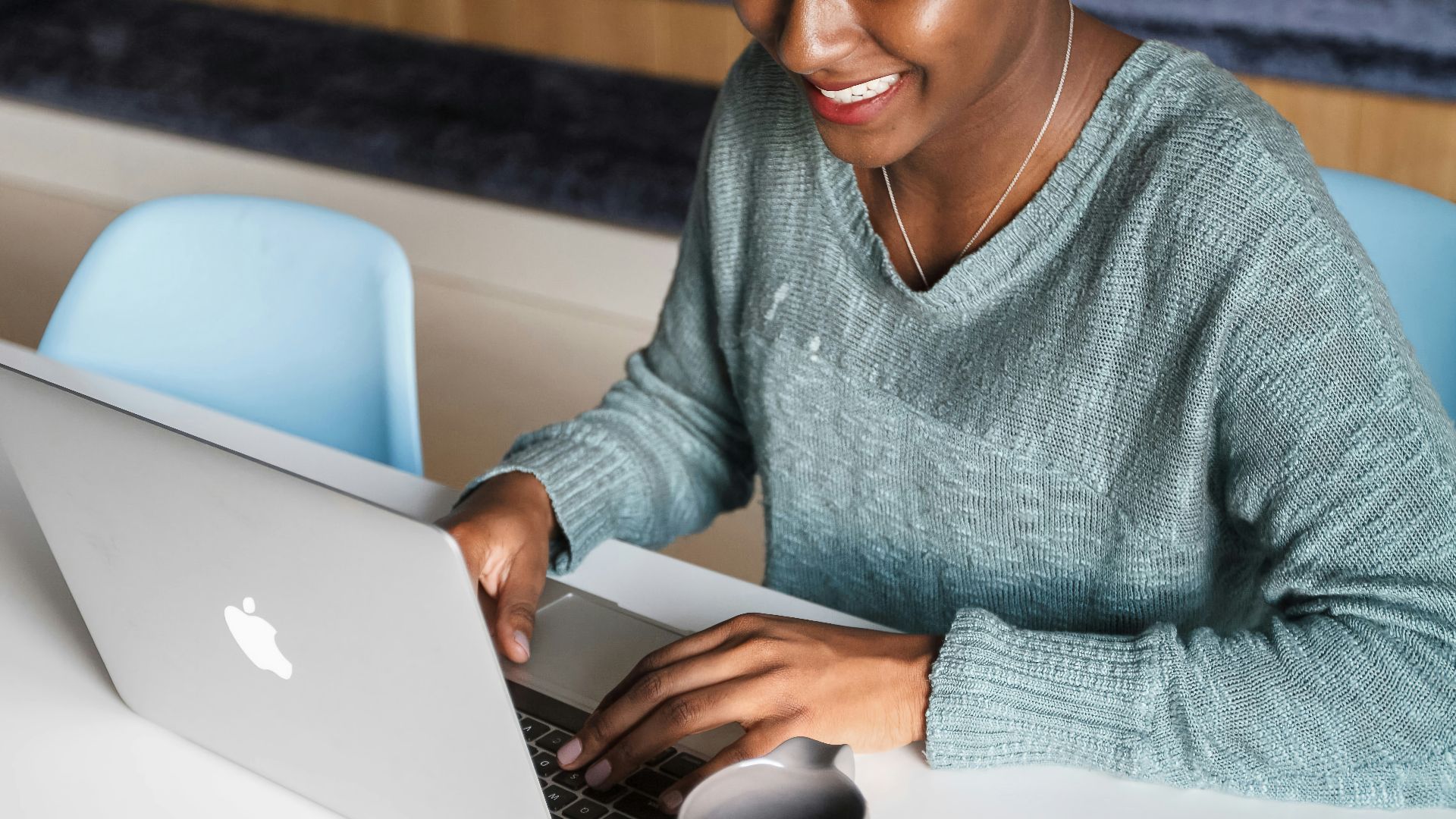 a woman sitting at a table using a laptop computer