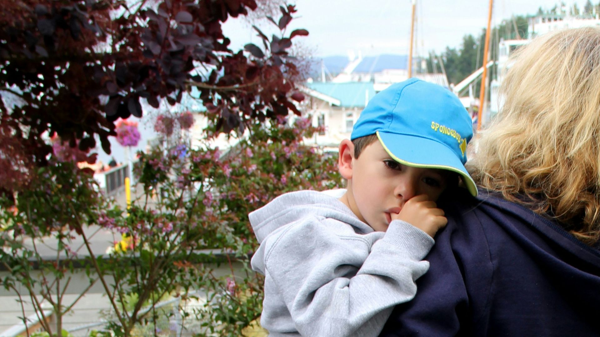woman in black jacket and blue cap standing near green plants during daytime
