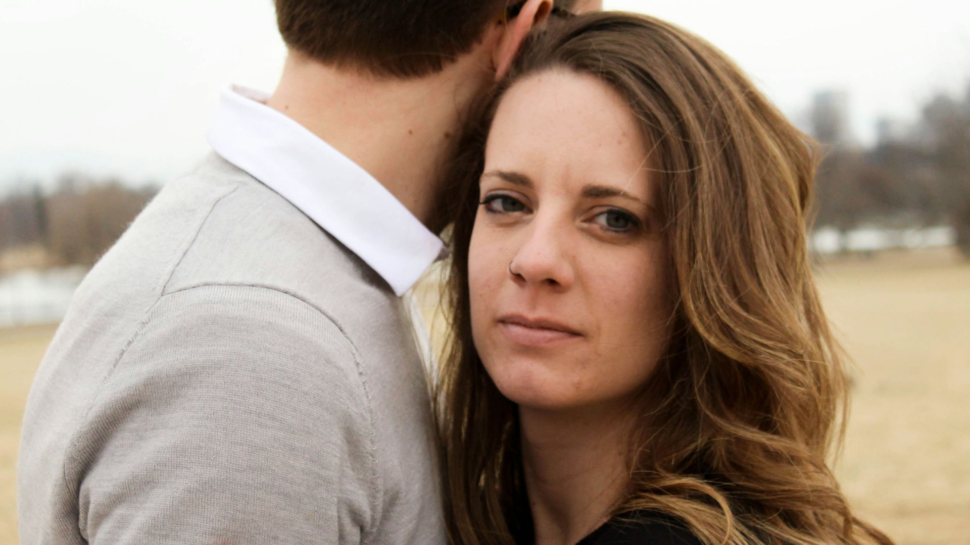 man in grey and white collared shirt and woman in black top