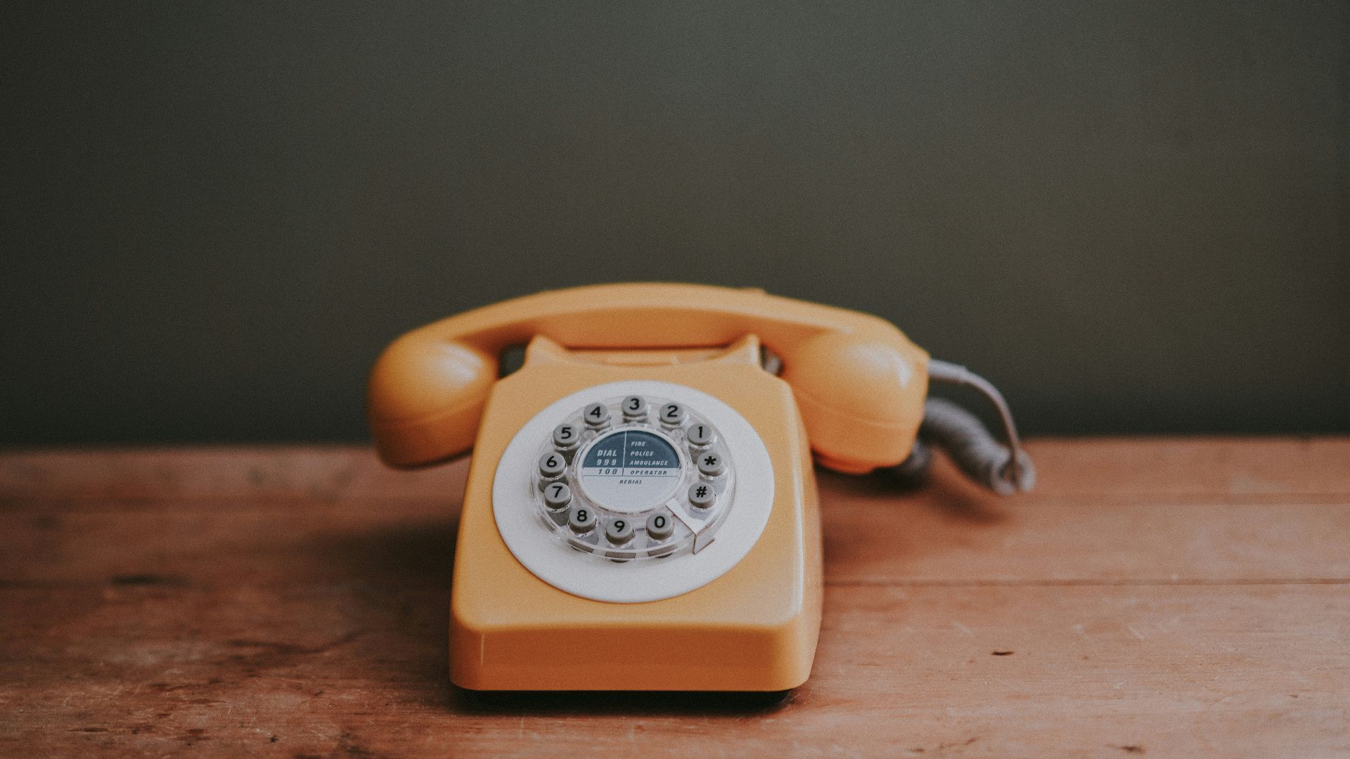 brown rotary dial telephone in gray painted room
