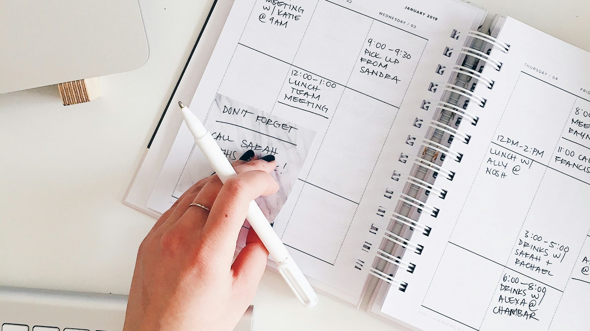 person holding notepad and pen flat lay photography