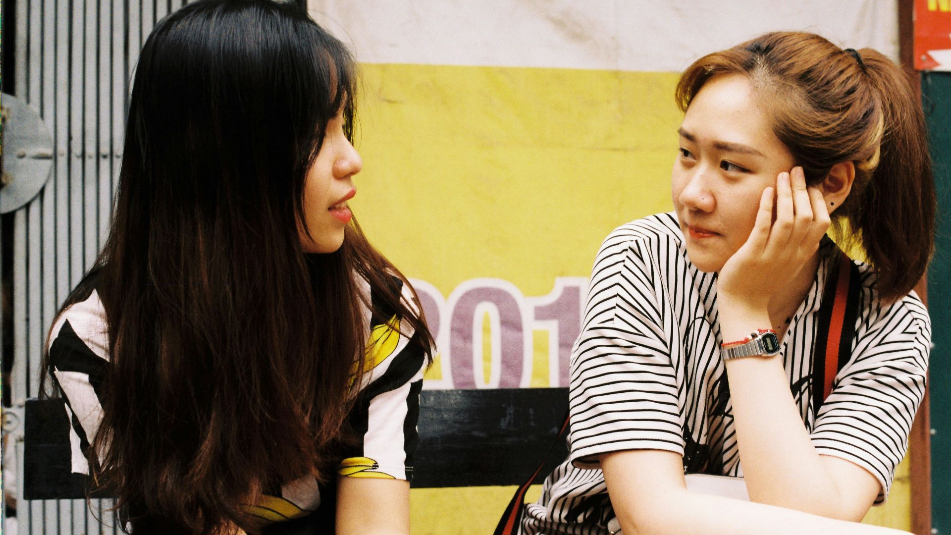 woman in white-and-black striped tops looking each other