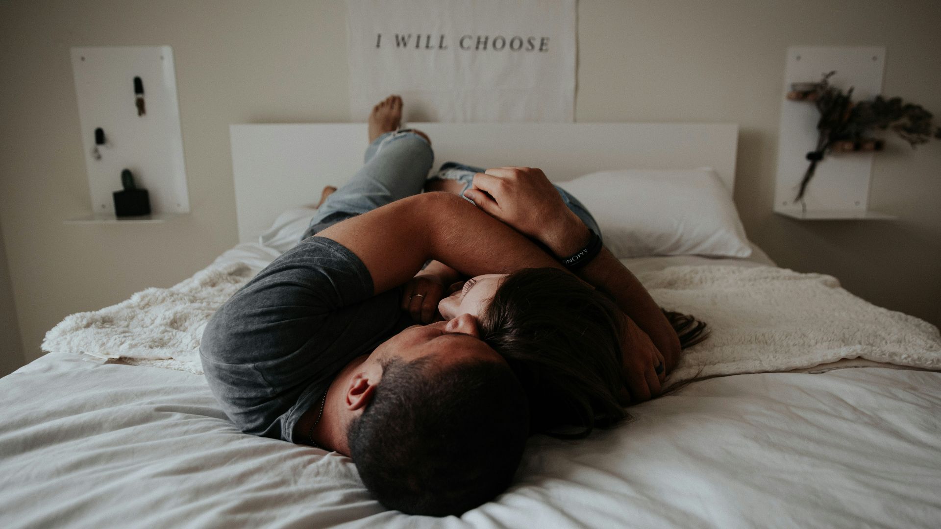 A man and woman cuddling together in bed.