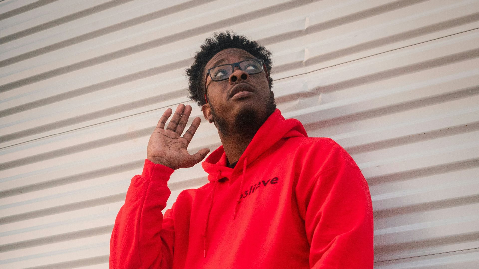 man in red dress shirt and blue denim jeans