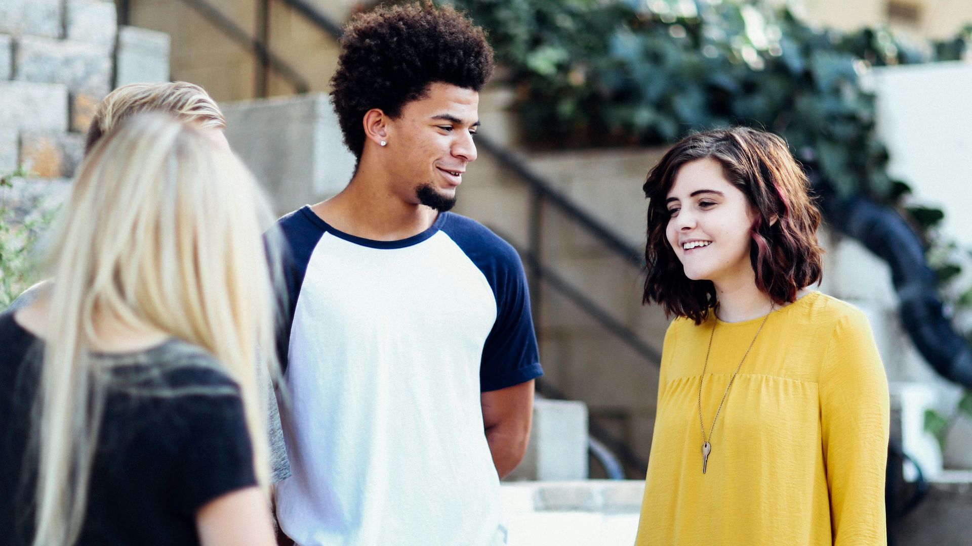 women and man talking outside the building