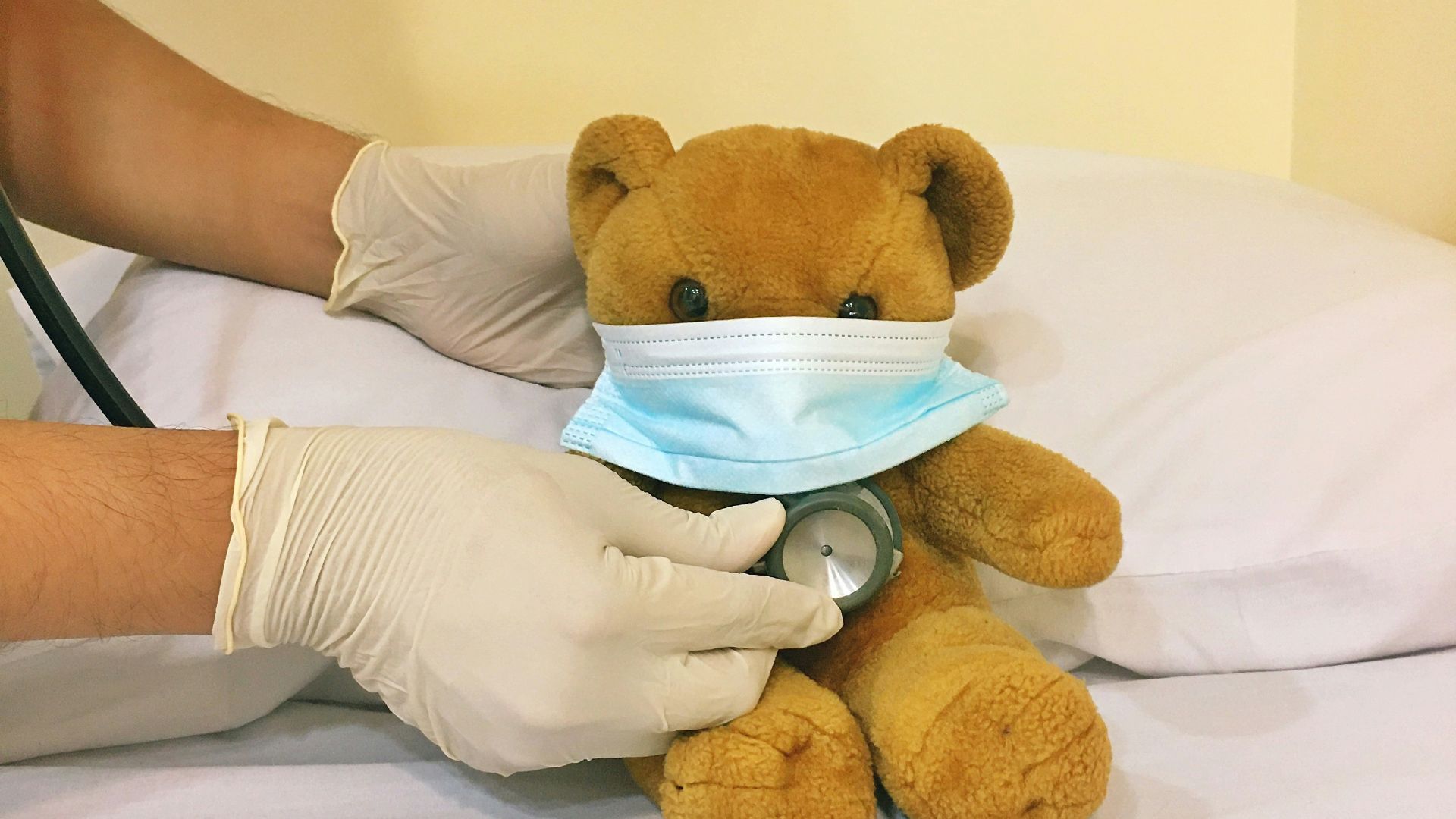 brown bear plush toy on white bed