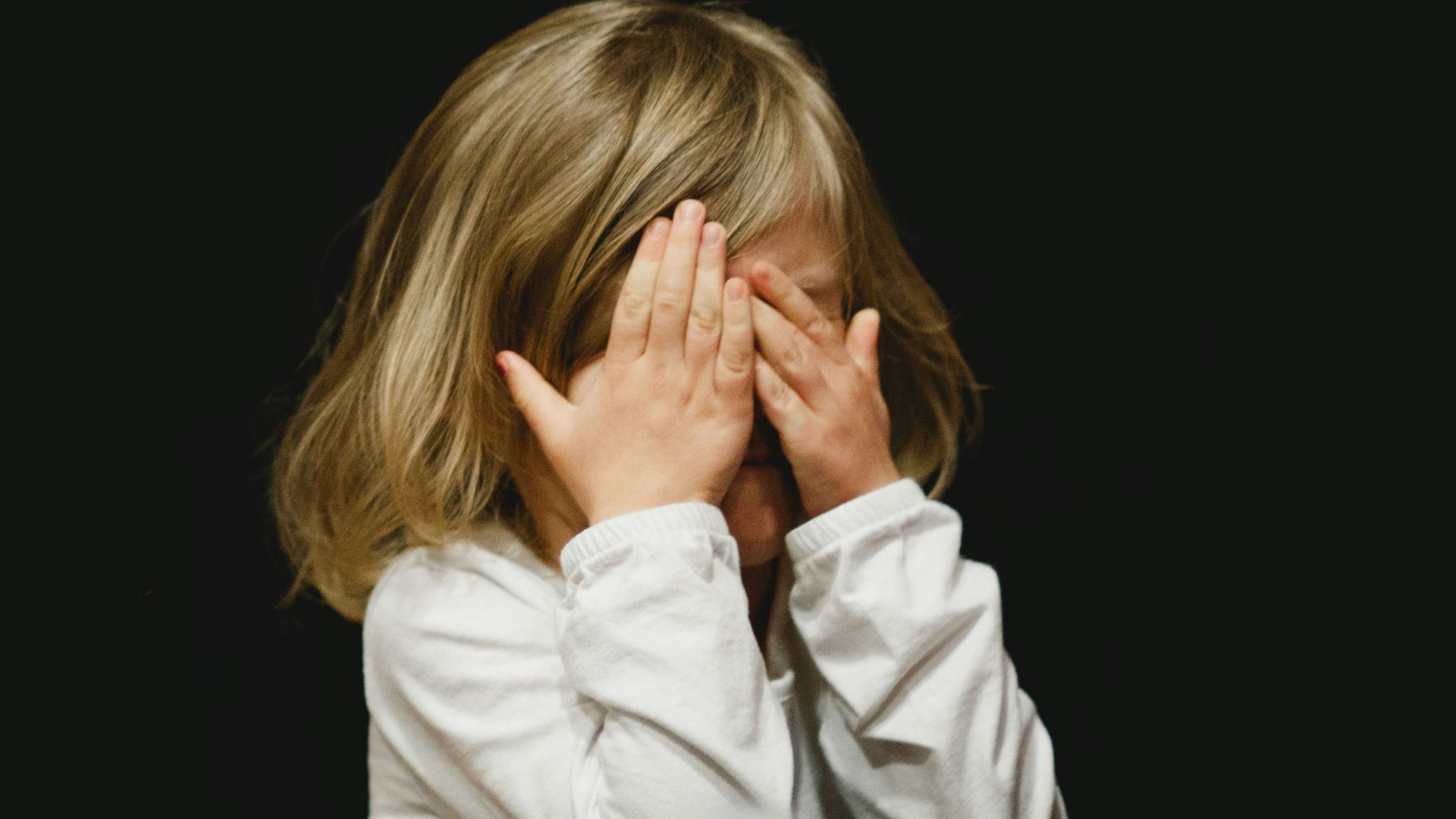 girl covering her face with both hands