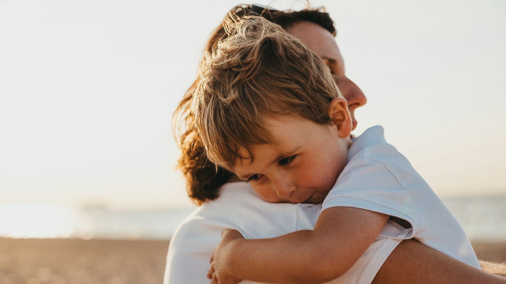 boy hugging woman during daytime