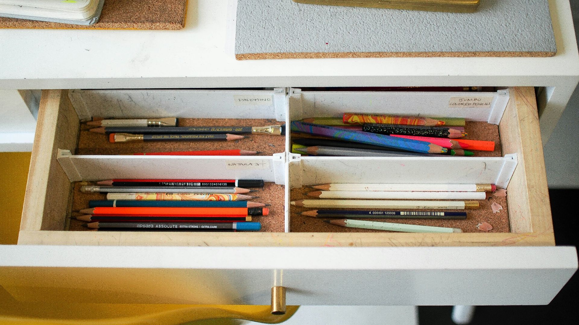 colored pencils in white wooden drawer