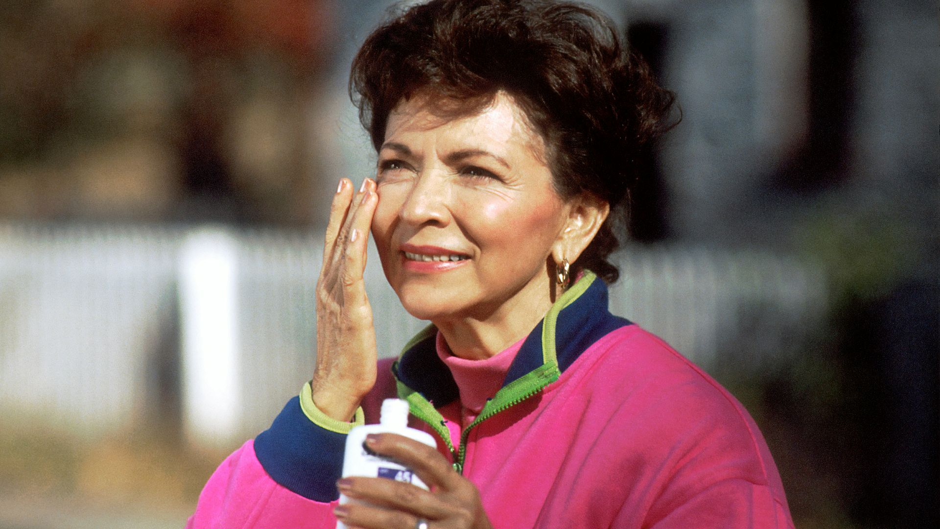 smiling woman in pink and blue shirt