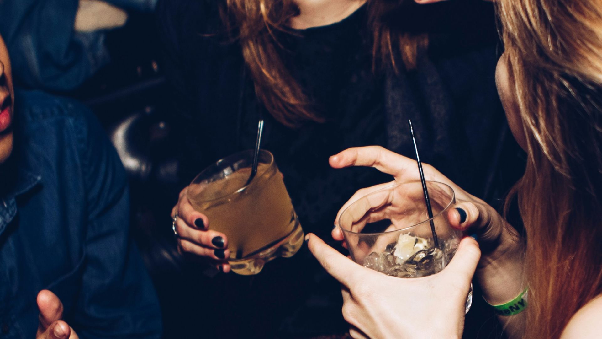 two women talking while holding drinking glasses
