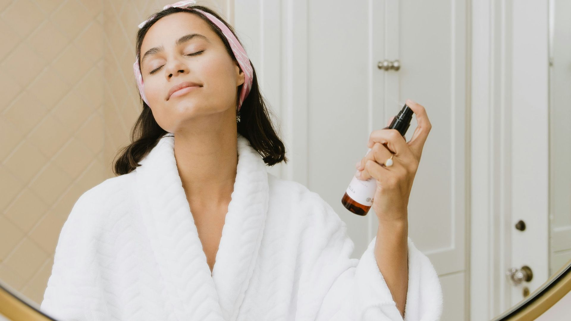 woman in white bathrobe holding smartphone