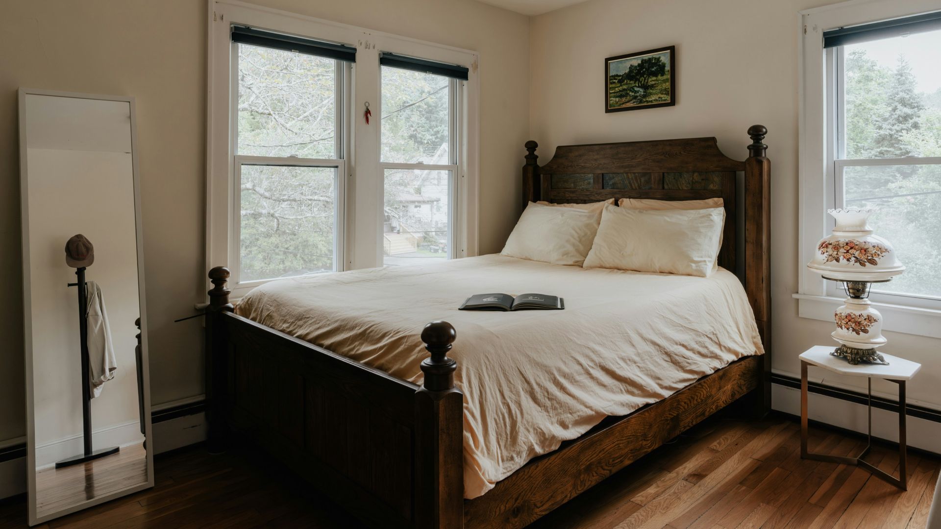 A bed sitting in a bedroom next to two windows