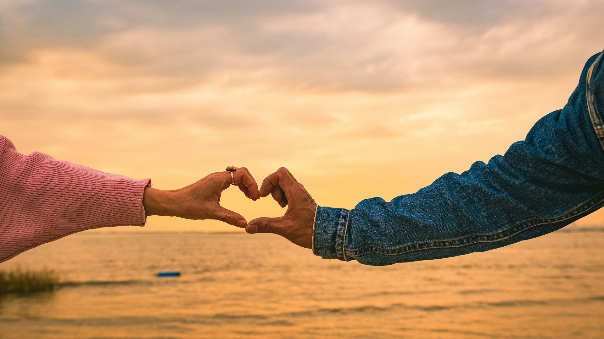 two people making a heart shape with their hands