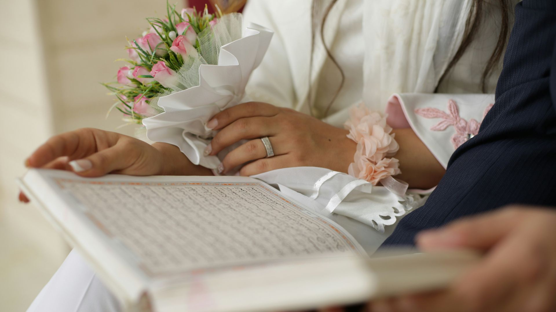 person in white dress shirt holding white book
