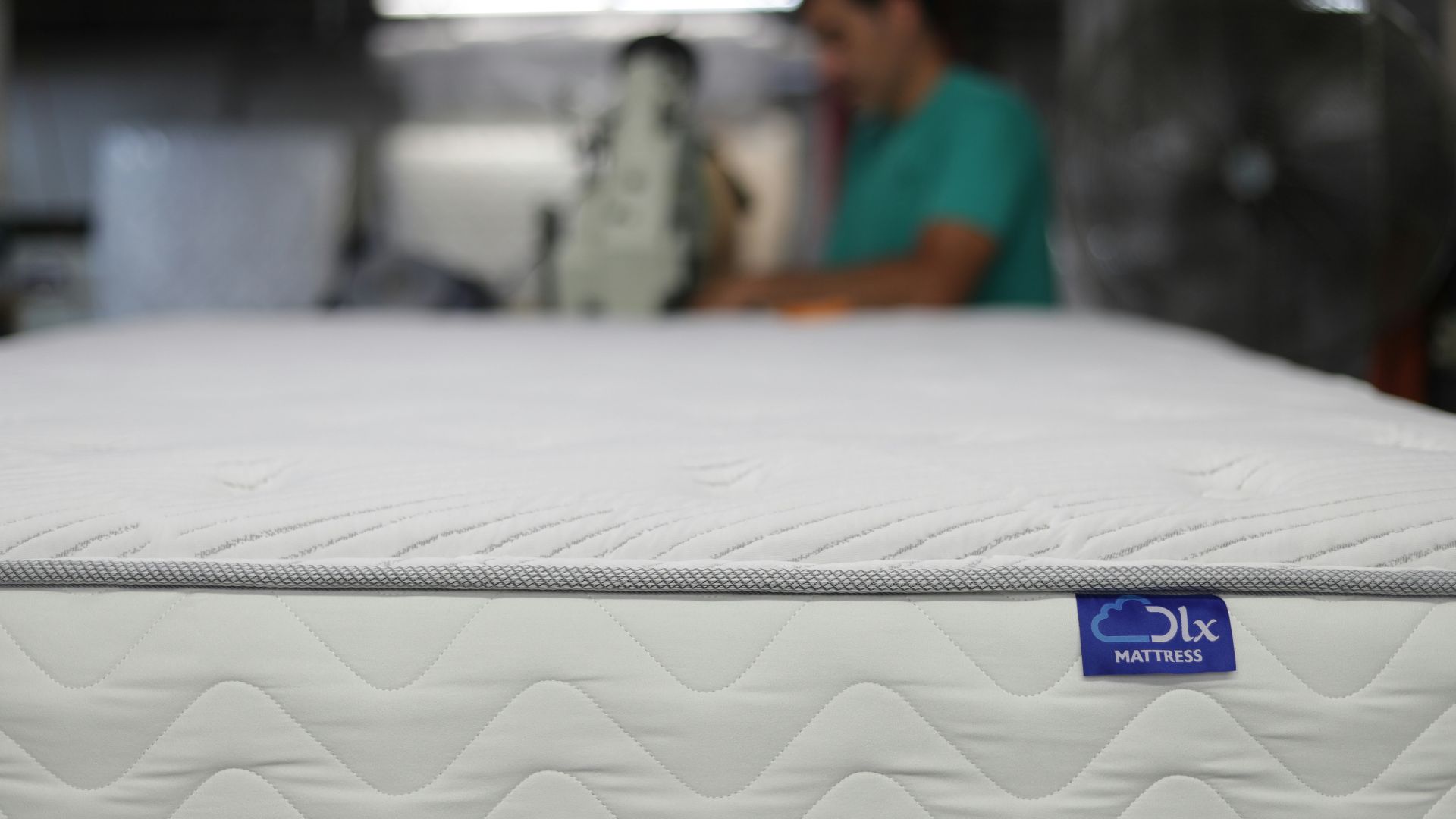 a man is working on a mattress in a warehouse