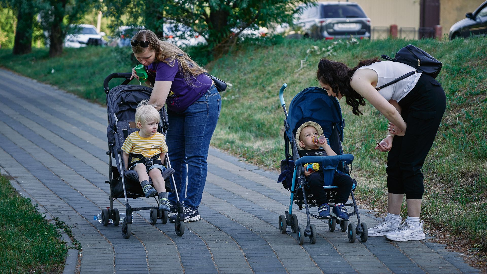 a woman pushing a stroller with two children in it