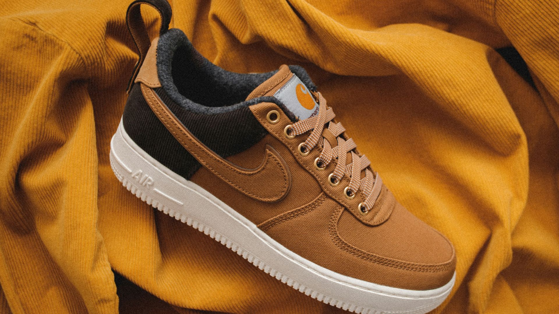 brown Nike sneaker on yellow textile