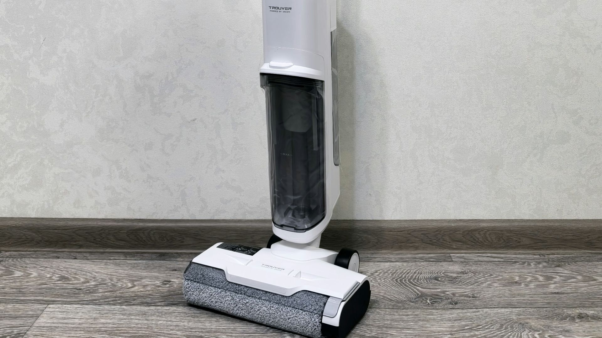 A floor sweeper sitting on top of a hard wood floor