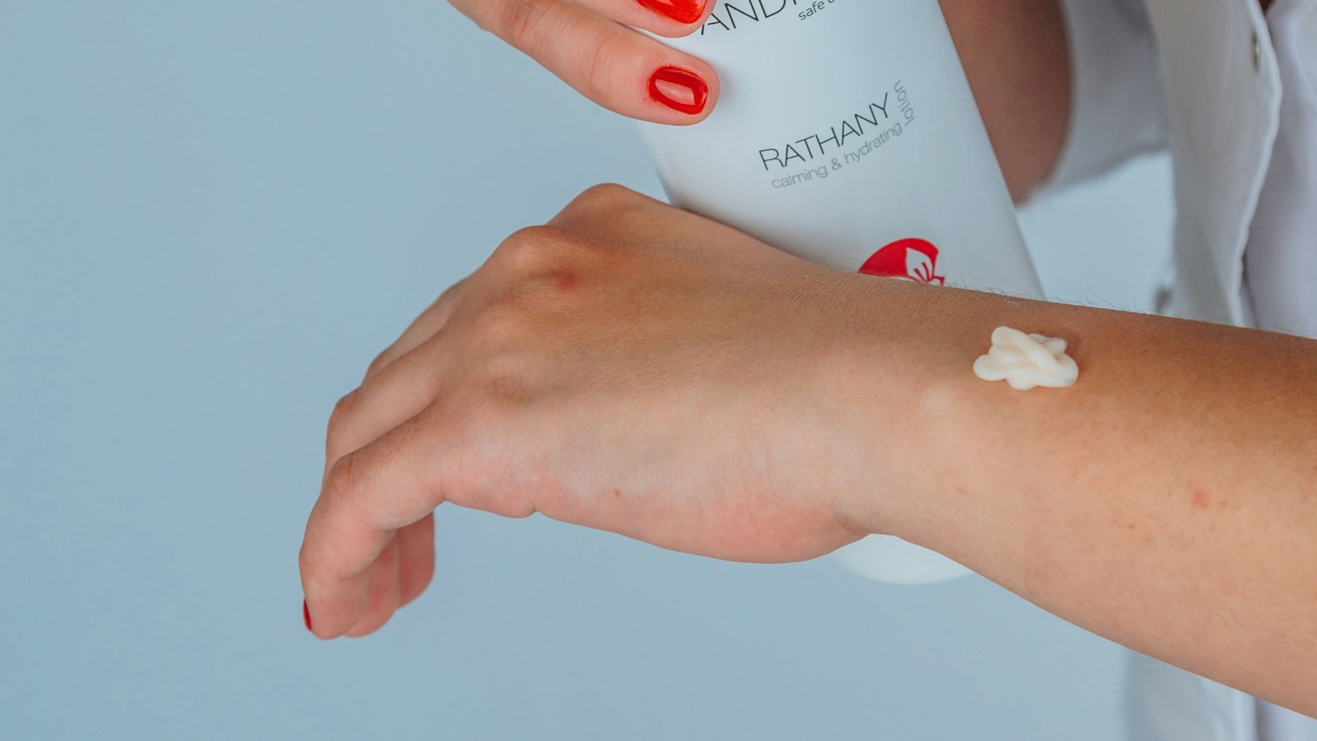 woman in white button up shirt holding white plastic bottle