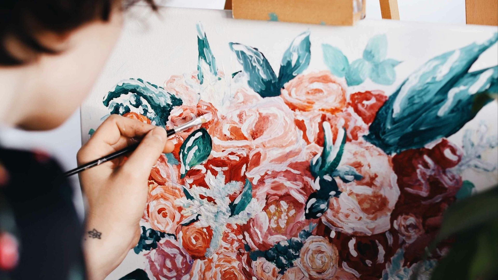 woman in red and white floral dress painting