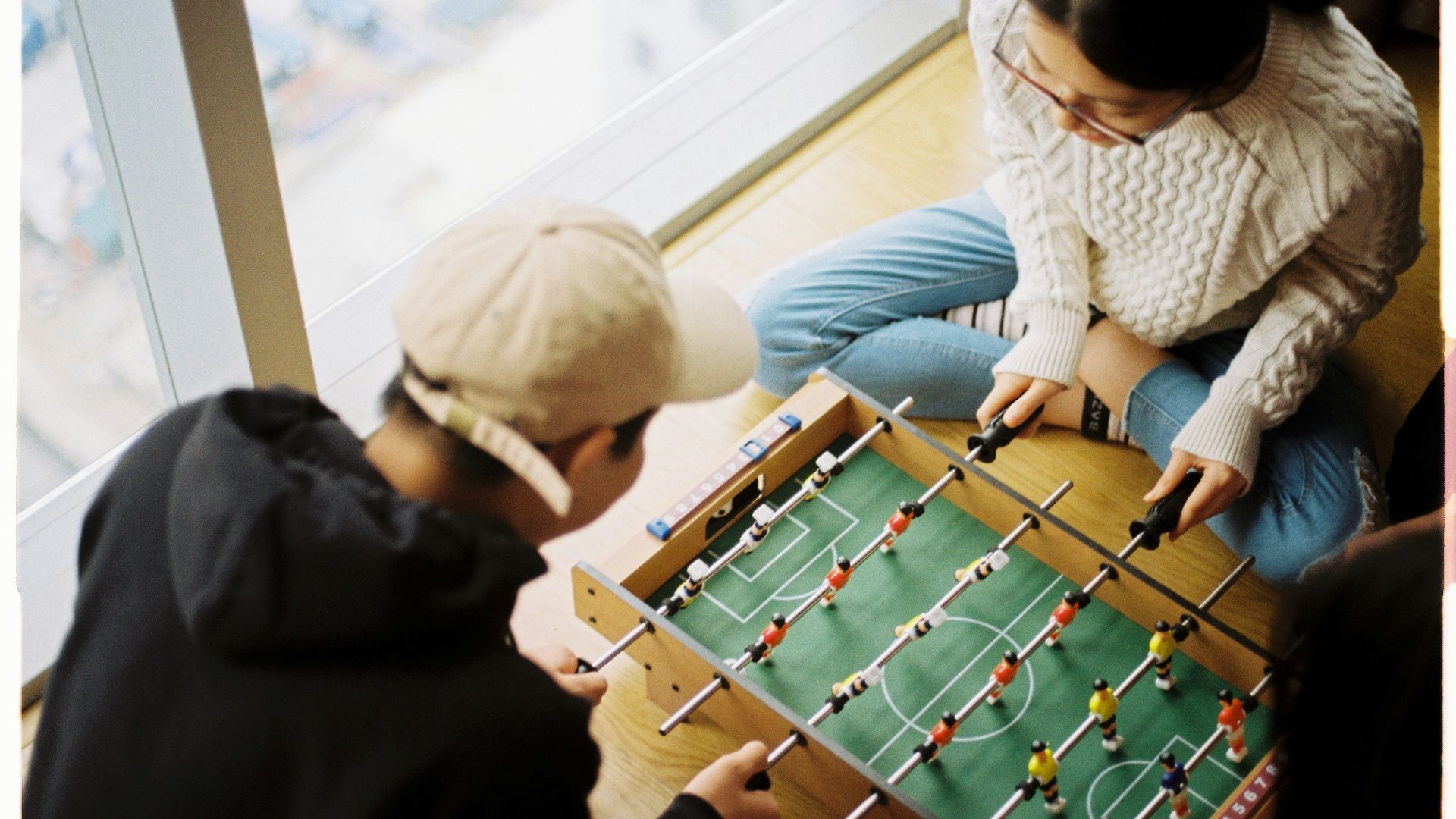 man and woman playing foosball table