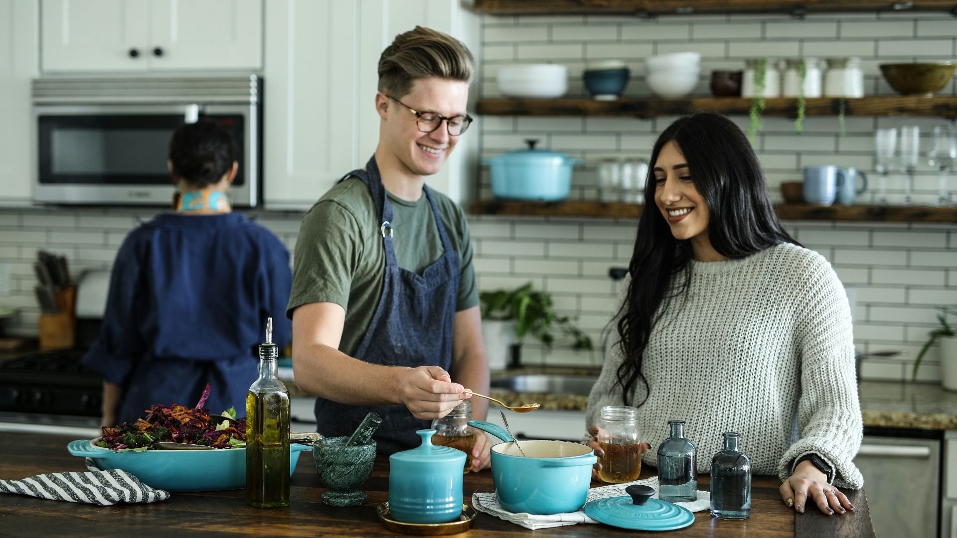 smiling man standing and mixing near woman in kitchen area of the house