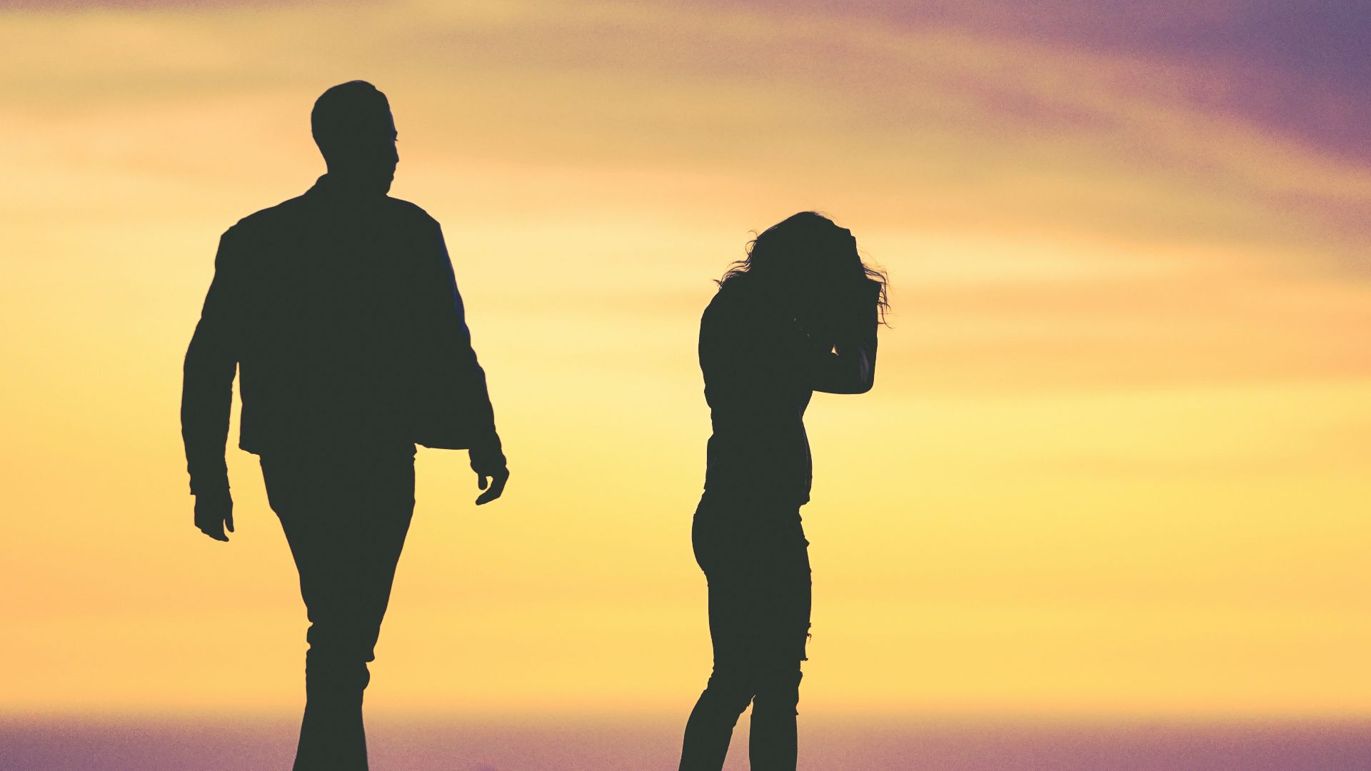 silhouette of man and woman under yellow sky