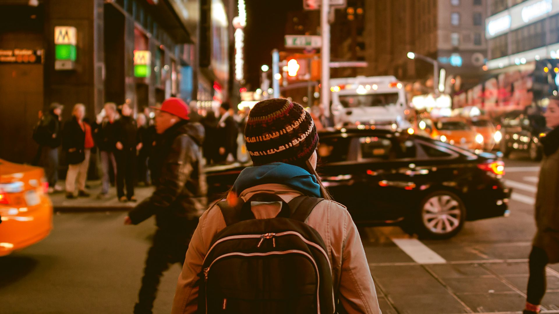 woman crossing highway during nighttime
