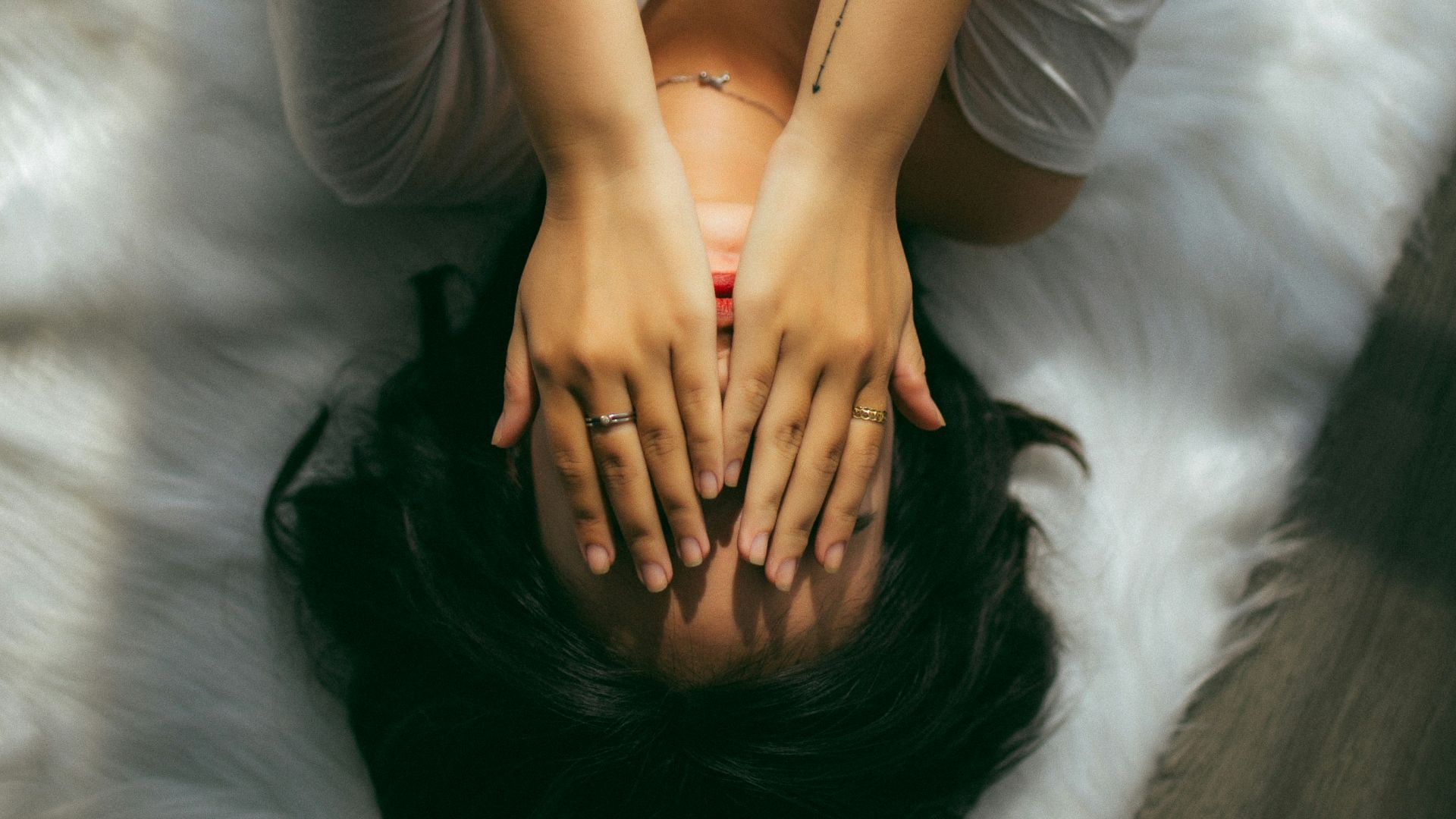 a woman holds her hands over her face