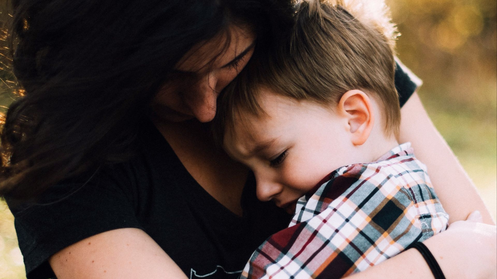 woman hugging boy on her lap