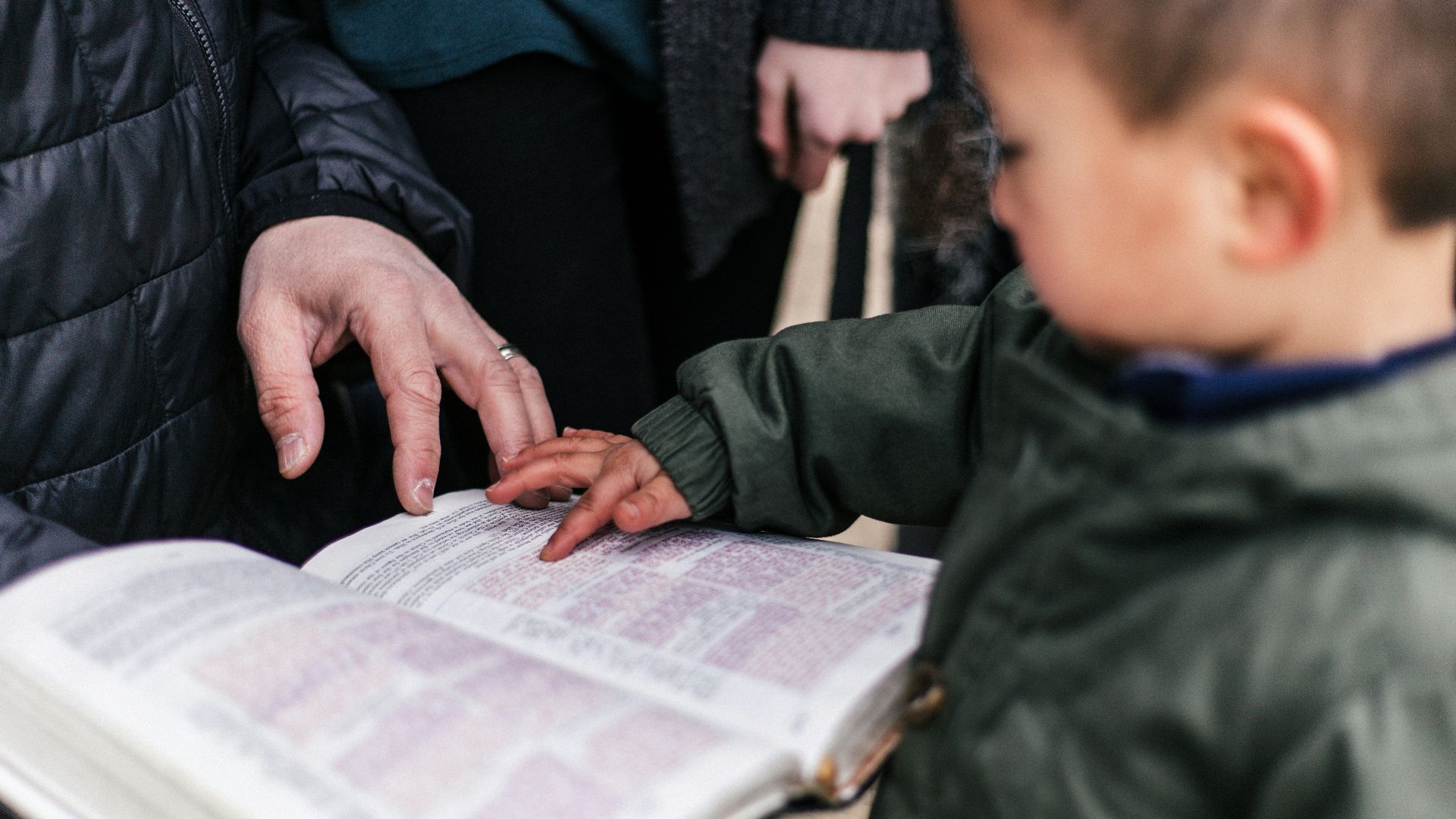 boy touching page of book