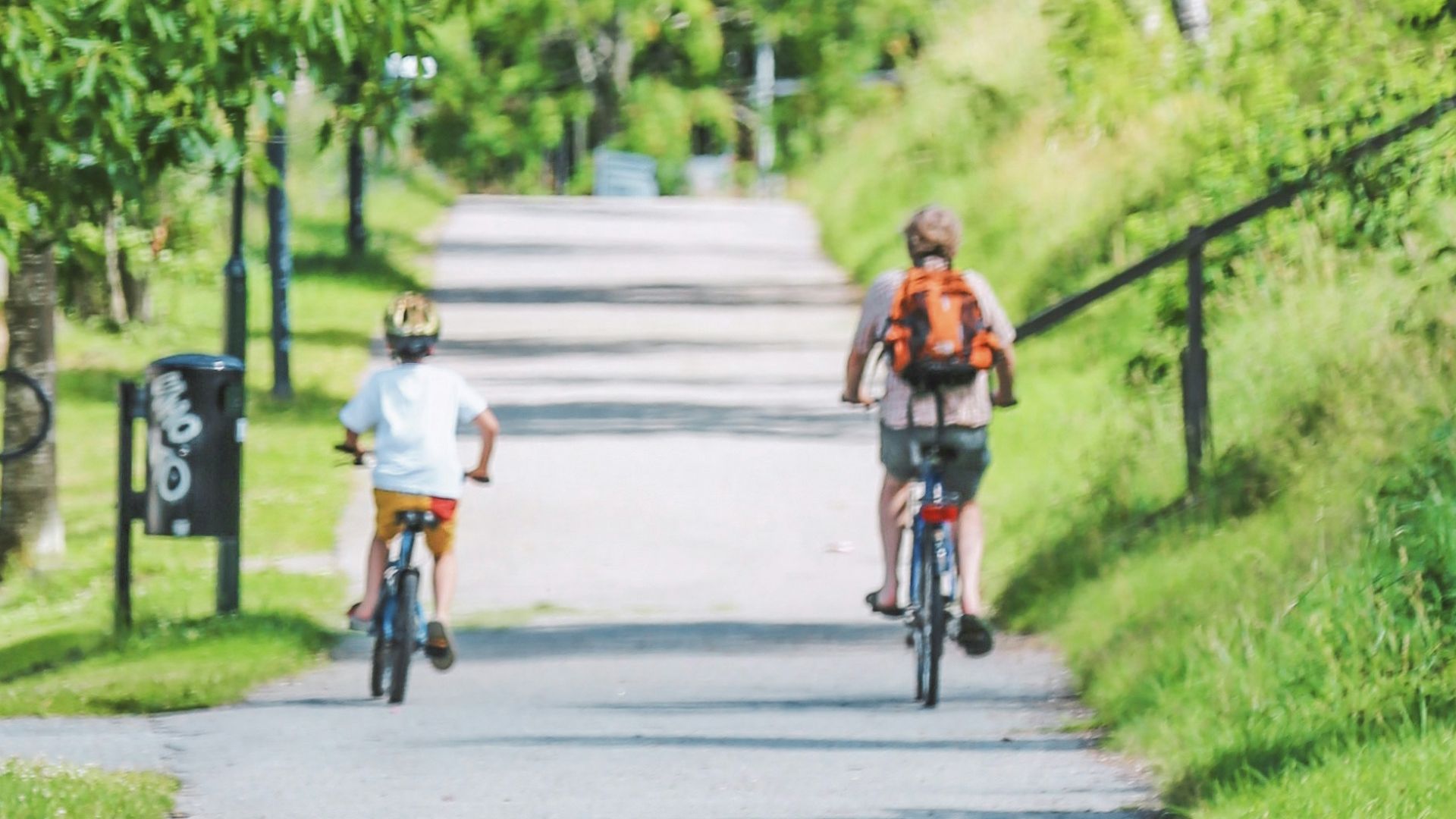 man in red shirt riding bicycle on road during daytime