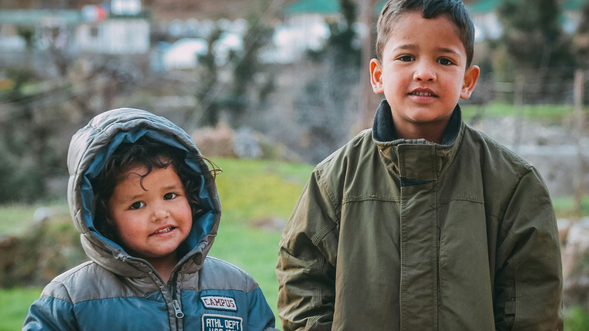 man in gray jacket beside boy in gray jacket