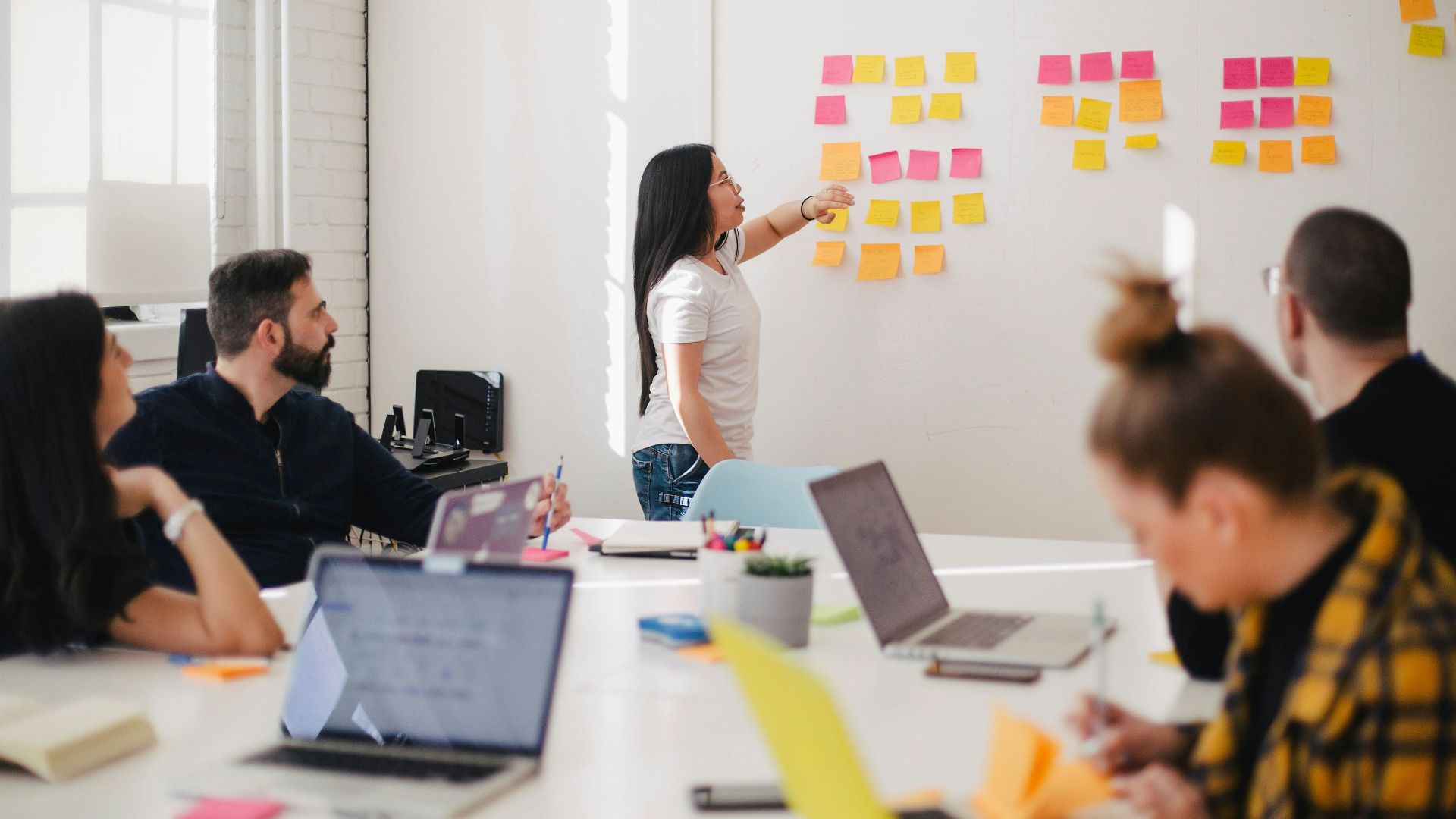 woman placing sticky notes on wall