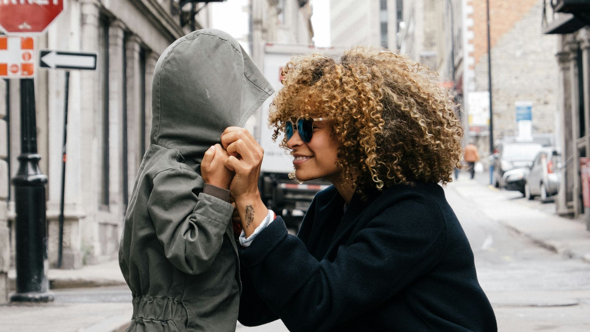 woman holding kid at the street