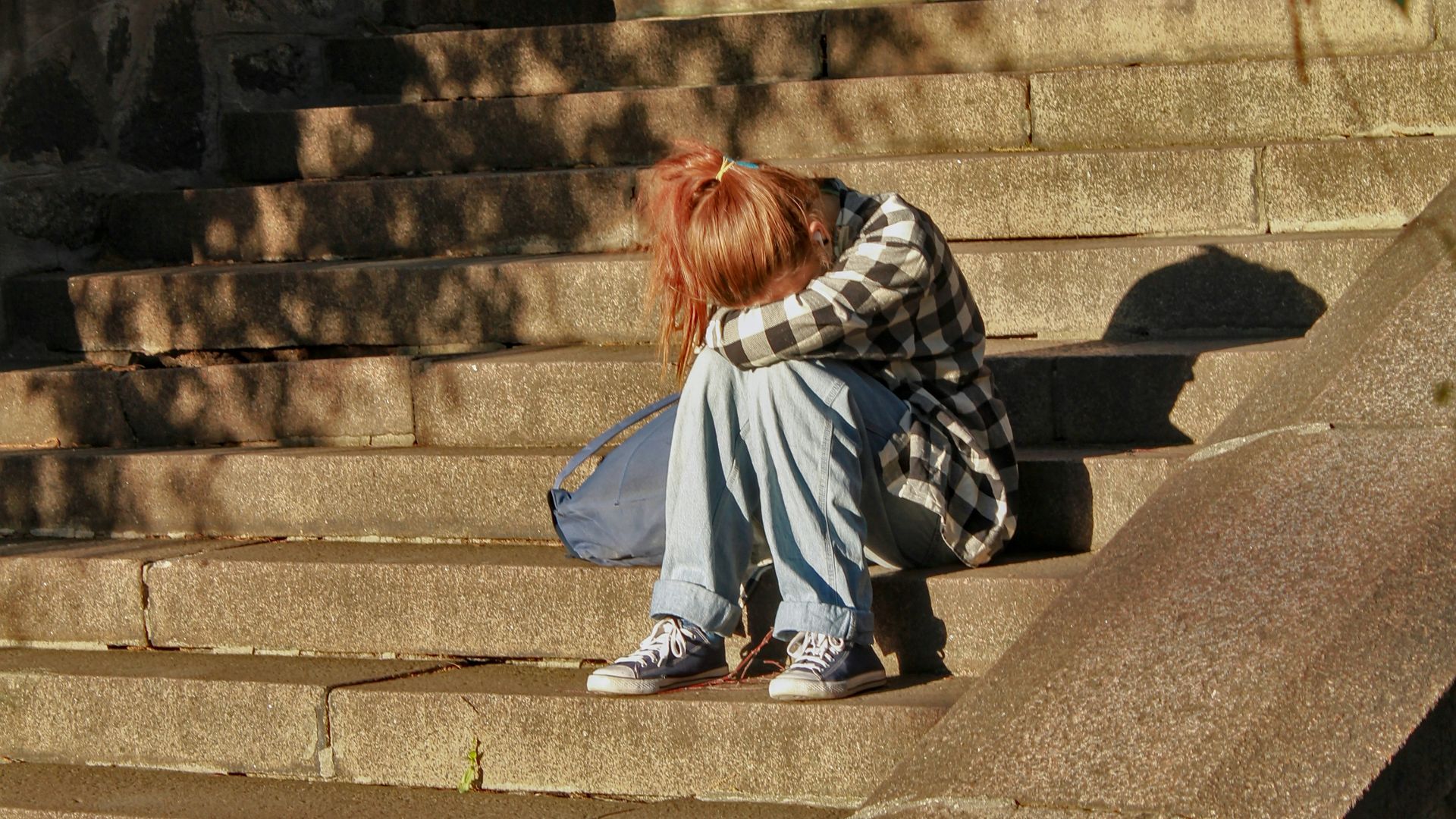 woman in black and white dress sitting on concrete stairs