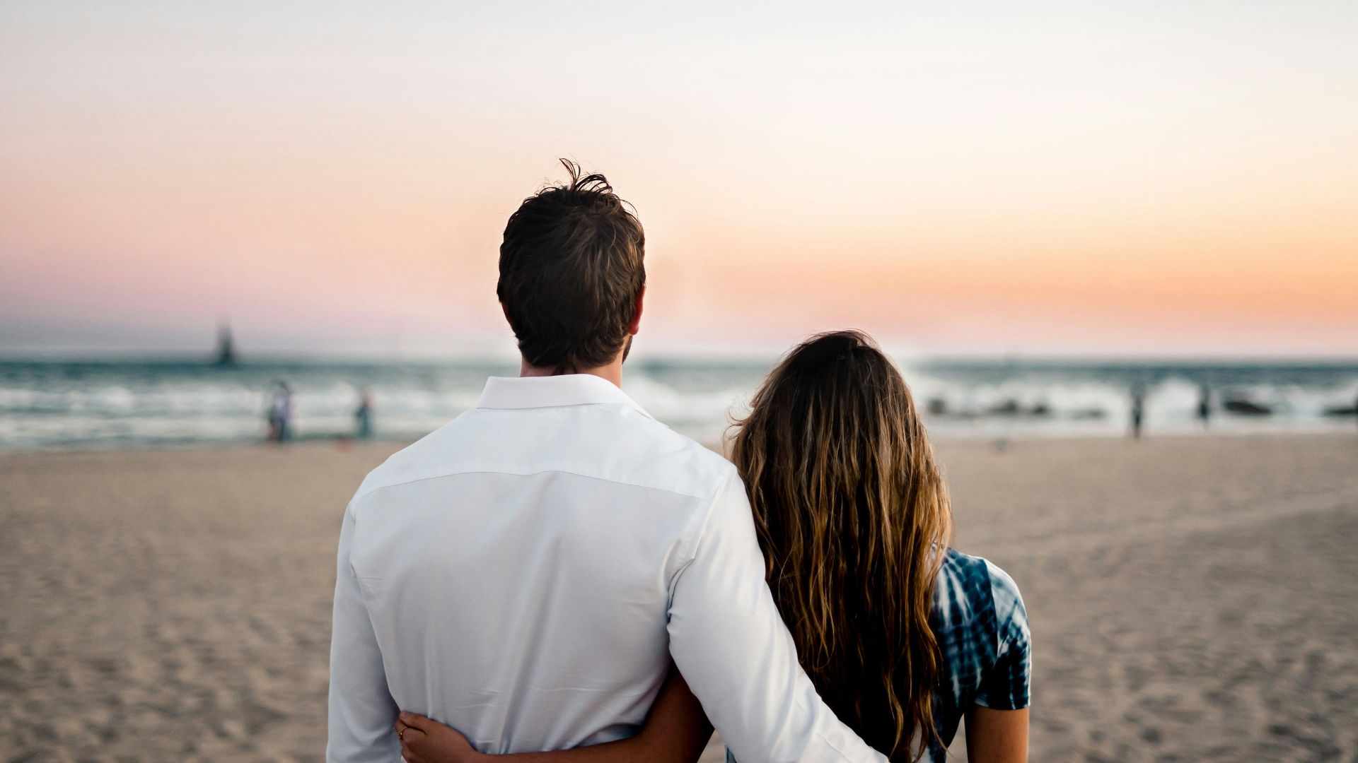 man and woman standing on brown sand during daytime