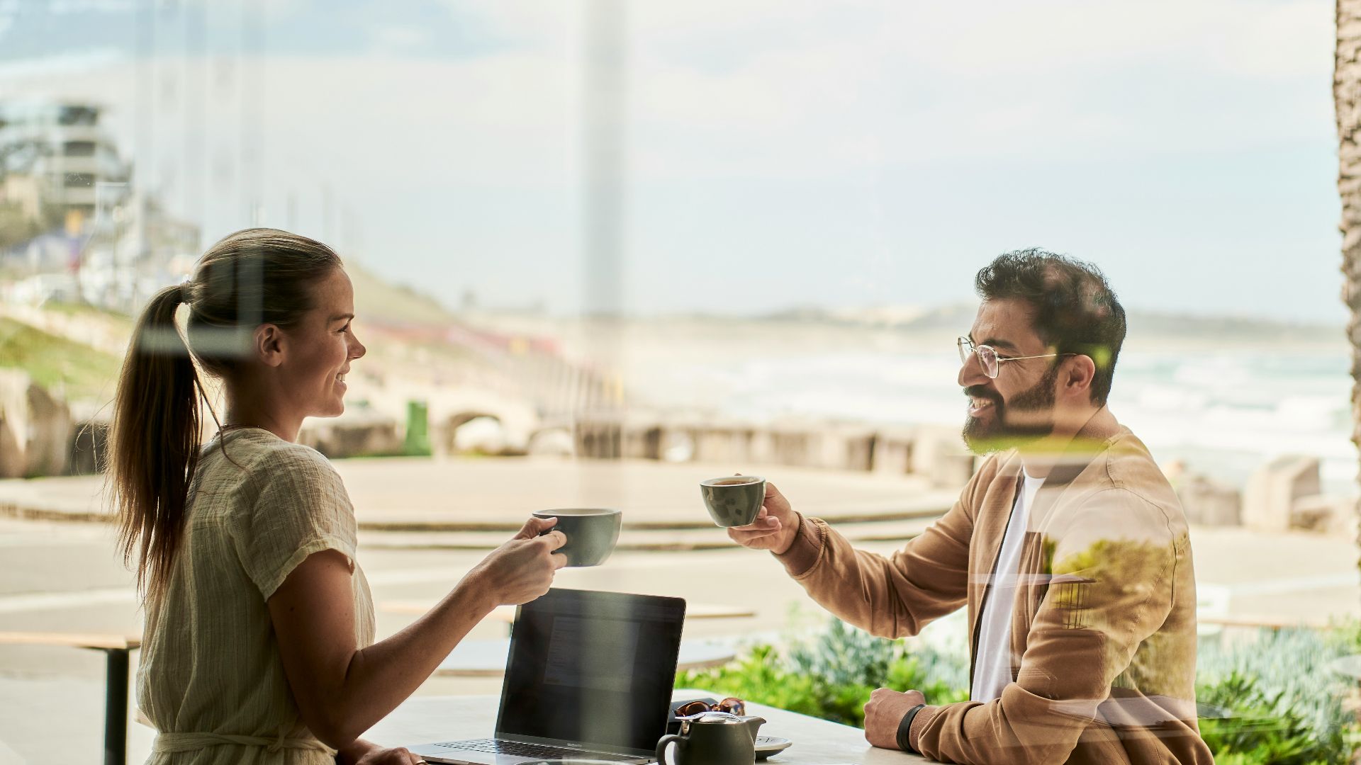 man in brown jacket sitting beside with woman at coffee shop